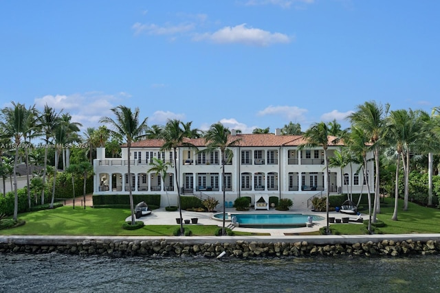 33 Arvida Pkwy, Coral Gables, FL 33156 - rear view of property featuring a balcony, a patio area, a yard, an outdoor pool, and a water view