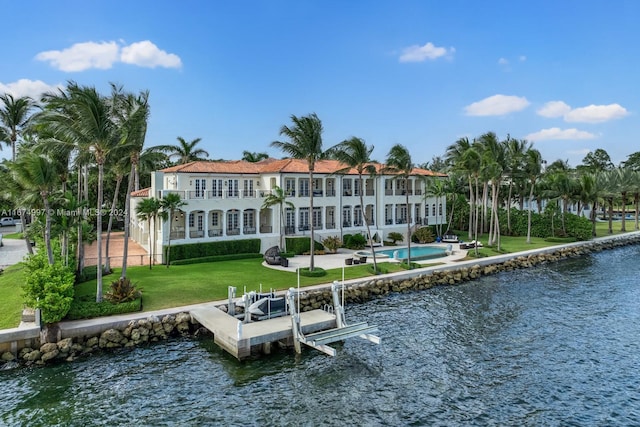 back of house featuring a water view, a patio area, and a yard