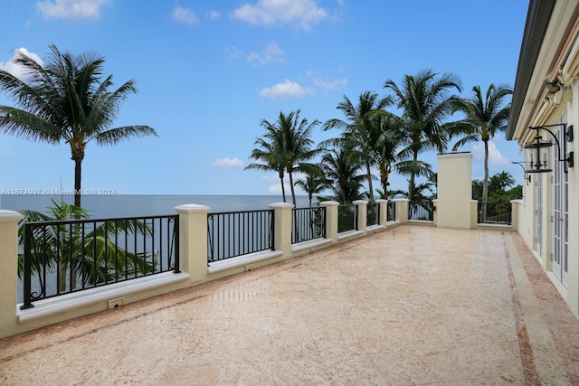 view of patio / terrace with a water view and a balcony