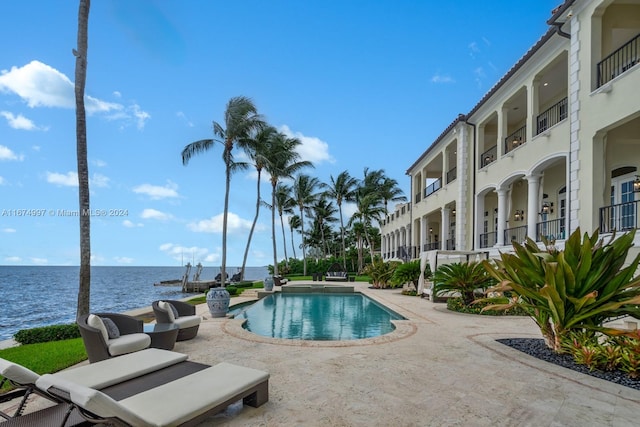 view of pool featuring a patio and a water view