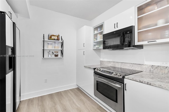 kitchen featuring black appliances, white cabinets, light stone countertops, and light hardwood / wood-style floors