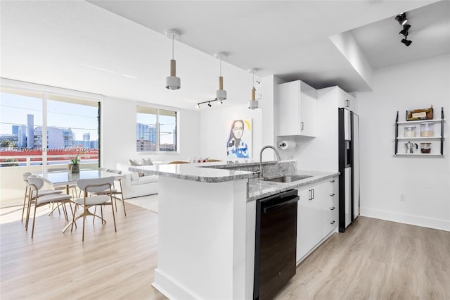 kitchen featuring white cabinetry, refrigerator with ice dispenser, dishwasher, pendant lighting, and sink