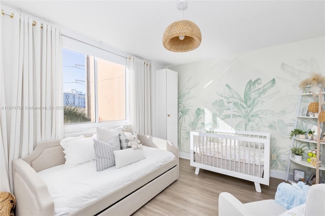 bedroom with light hardwood / wood-style floors and multiple windows