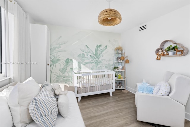 bedroom featuring a crib and hardwood / wood-style floors