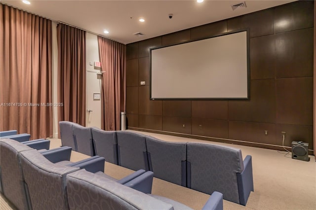 home theater room featuring light carpet and wood walls