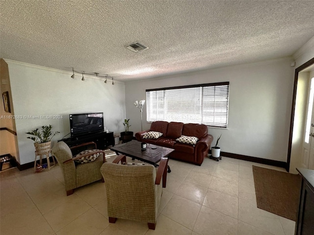 tiled living room featuring rail lighting and a textured ceiling