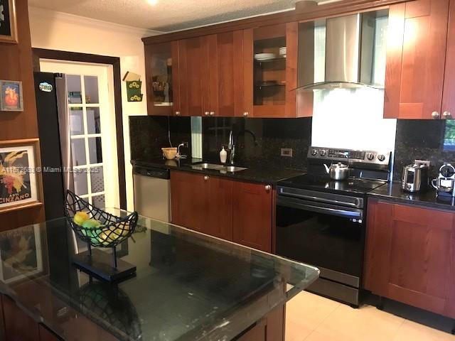 kitchen with ceiling fan, stainless steel refrigerator with ice dispenser, a textured ceiling, light tile patterned floors, and ornamental molding