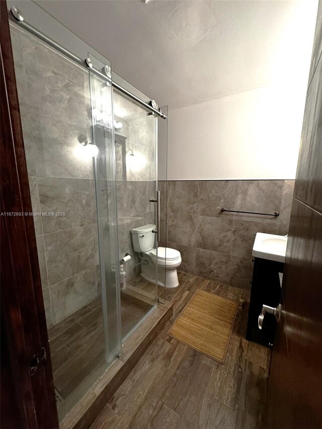 bathroom with hardwood / wood-style floors, vanity, and tile walls