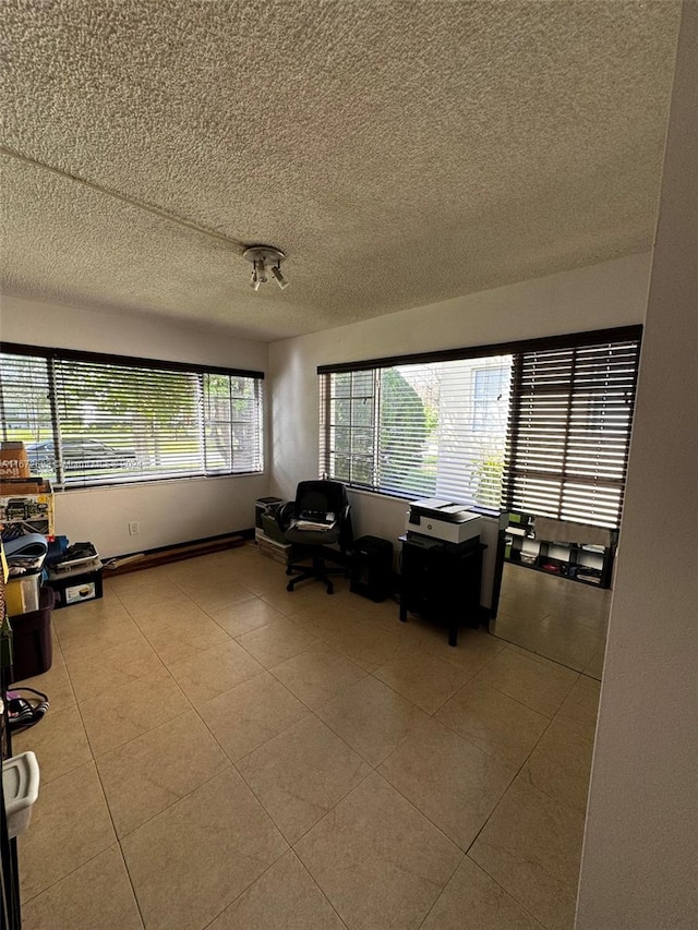 unfurnished office featuring light tile patterned floors and a textured ceiling