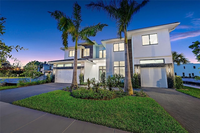 contemporary home with a garage and a lawn