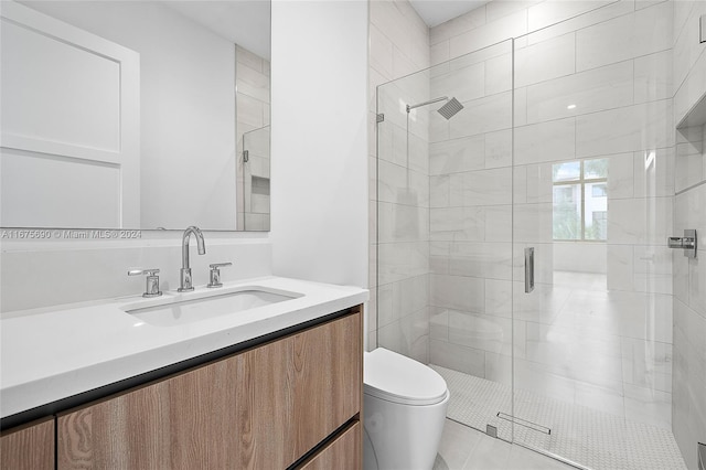 bathroom with vanity, toilet, tile patterned floors, and a shower with door