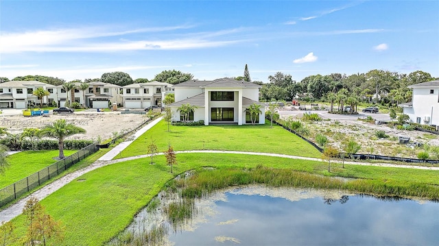 back of house featuring a water view and a lawn