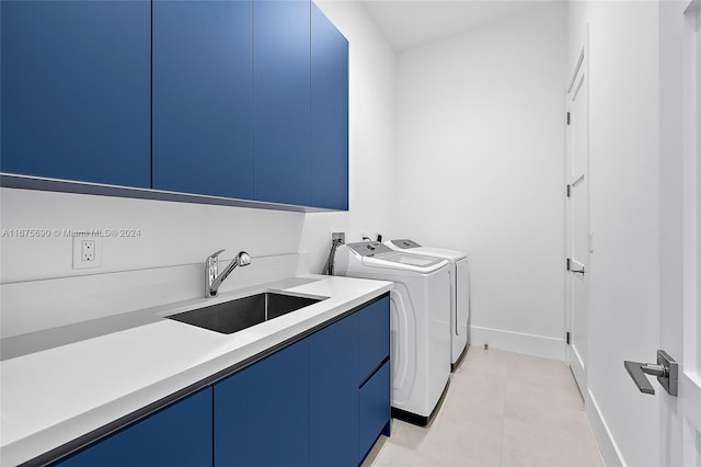 laundry area with cabinets, sink, washer and clothes dryer, and light tile patterned floors