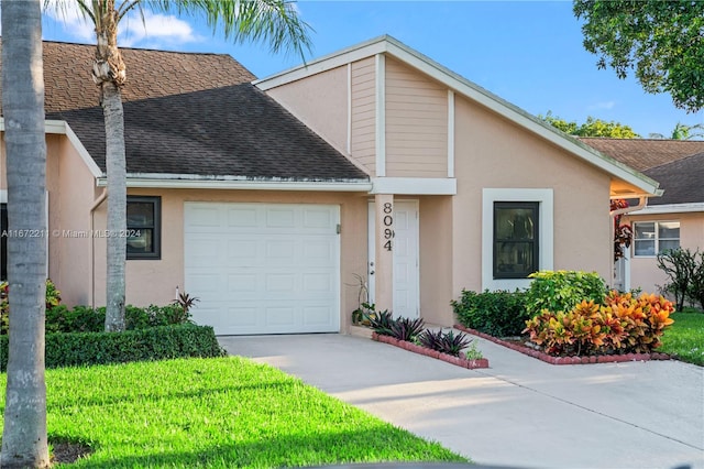 view of front of home with a garage and a front lawn