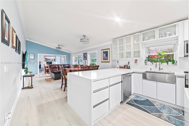 kitchen featuring stainless steel appliances, light hardwood / wood-style flooring, lofted ceiling, kitchen peninsula, and ornamental molding