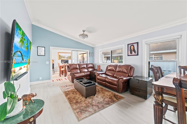 living room featuring ornamental molding, a wealth of natural light, vaulted ceiling, and light hardwood / wood-style floors