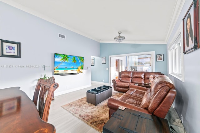 living room featuring vaulted ceiling, light hardwood / wood-style flooring, and ornamental molding