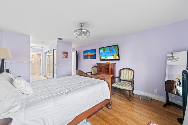 bedroom with ensuite bath and light hardwood / wood-style flooring