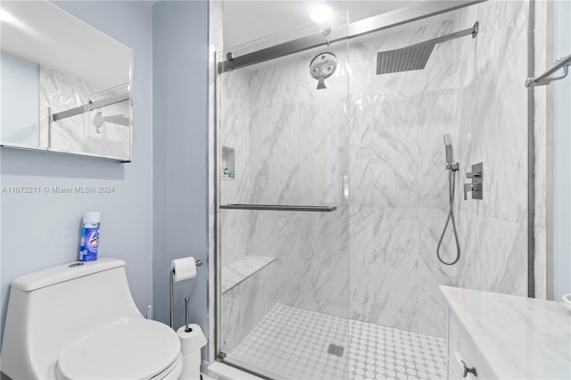 bathroom featuring a shower with shower door, vanity, and toilet