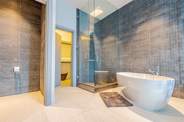 bathroom featuring tile patterned flooring, tile walls, and independent shower and bath