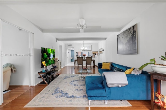 living room featuring ceiling fan with notable chandelier and hardwood / wood-style floors