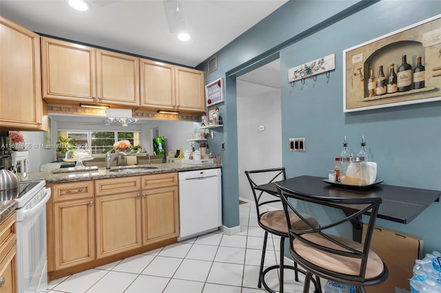 kitchen featuring white appliances, light brown cabinets, sink, light stone countertops, and light tile patterned floors