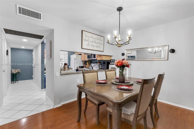 dining area featuring light hardwood / wood-style flooring and a chandelier