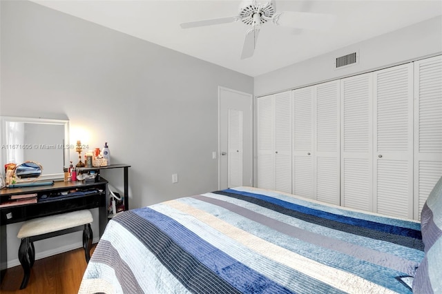 bedroom with ceiling fan, dark wood-type flooring, and a closet