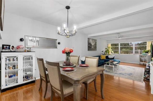 dining room featuring ceiling fan with notable chandelier and hardwood / wood-style floors