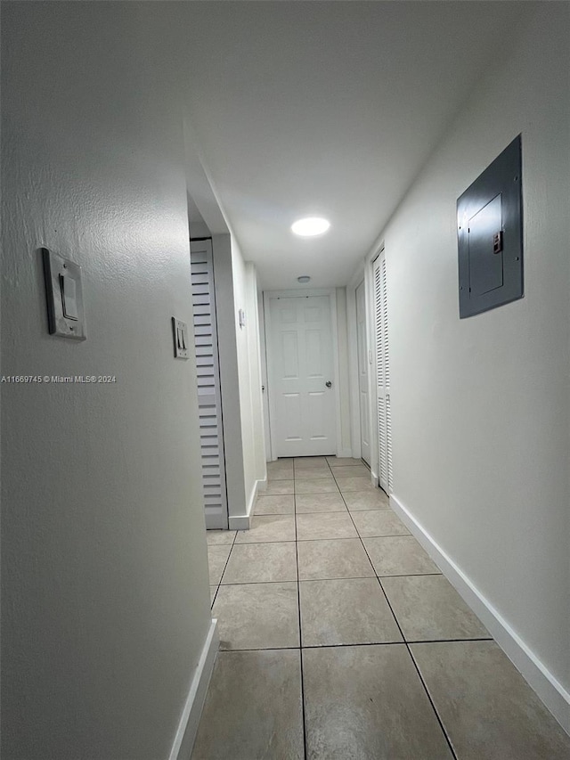 corridor with electric panel and light tile patterned floors