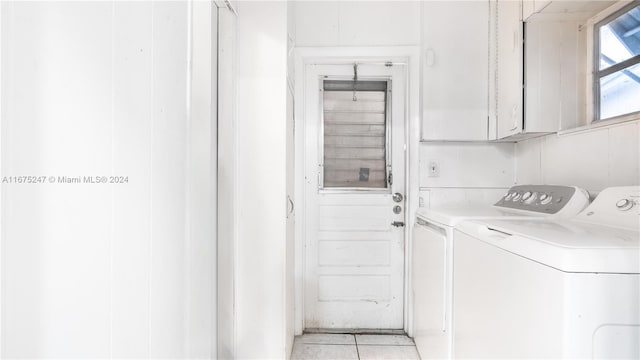 laundry room with cabinets, light tile patterned floors, and washing machine and dryer