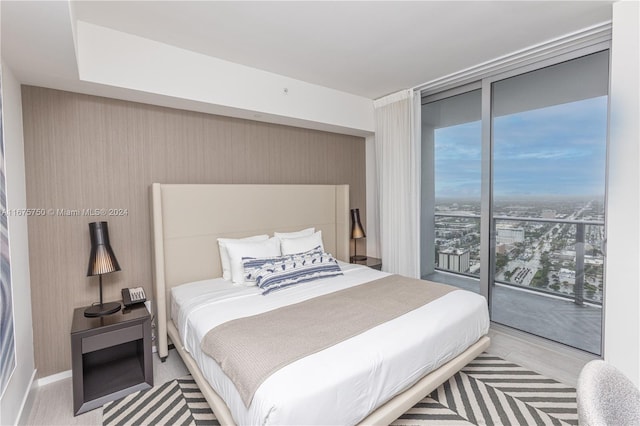 bedroom with light hardwood / wood-style flooring, access to outside, and floor to ceiling windows