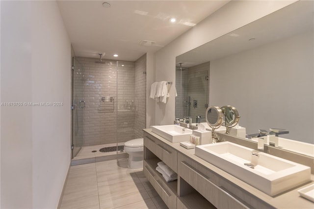 bathroom featuring a shower with door, vanity, toilet, and tile patterned floors