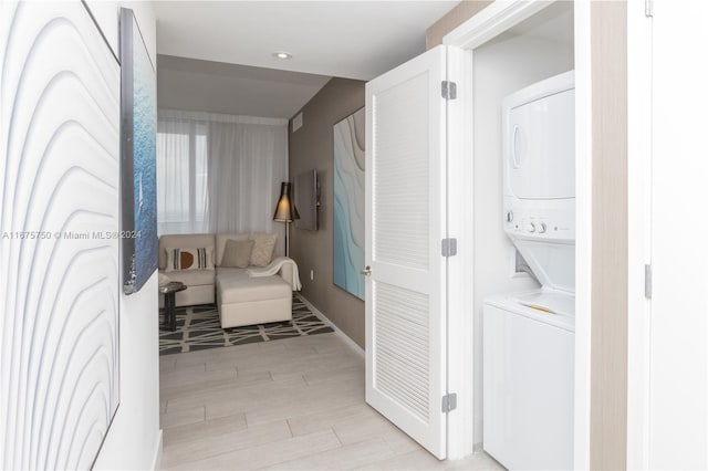 laundry area featuring light hardwood / wood-style floors and stacked washer and clothes dryer