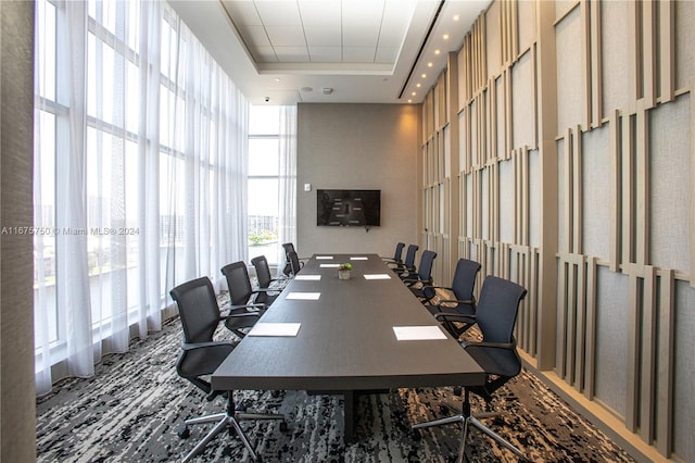 office space featuring a towering ceiling, carpet floors, and a tray ceiling