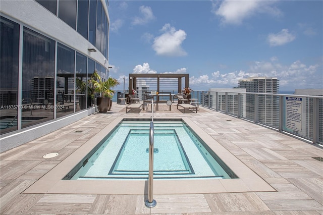 view of swimming pool featuring a patio area and a hot tub