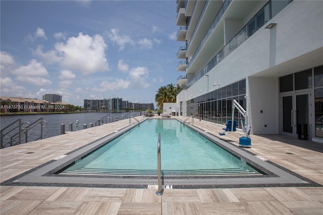 view of swimming pool featuring a patio and a water view