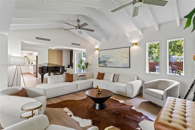 living room with beamed ceiling, light wood-type flooring, high vaulted ceiling, and ceiling fan