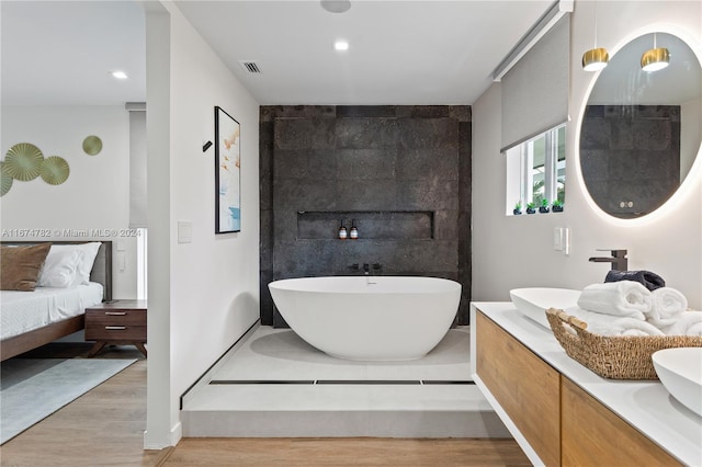 bathroom featuring hardwood / wood-style flooring, vanity, and a bathing tub