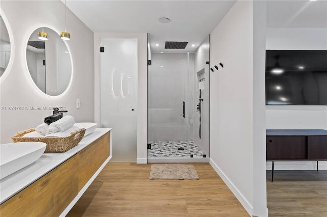 bathroom featuring vanity, wood-type flooring, and a shower with shower door