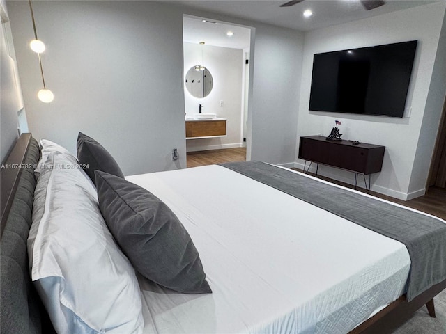 bedroom with hardwood / wood-style flooring and ensuite bath