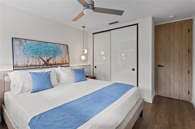 bedroom with ceiling fan, a closet, and dark wood-type flooring