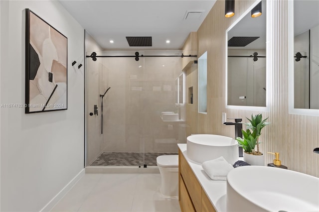 bathroom featuring tile patterned floors, vanity, toilet, and a shower with shower door