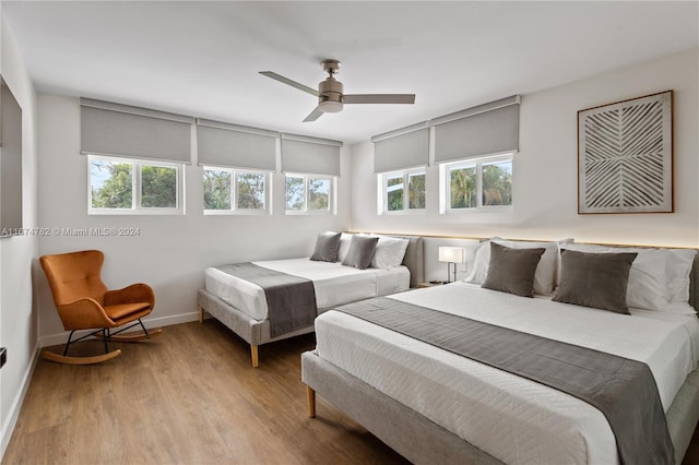 bedroom with light hardwood / wood-style floors, multiple windows, and ceiling fan