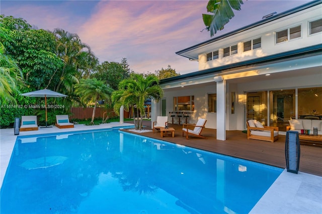 pool at dusk featuring a deck