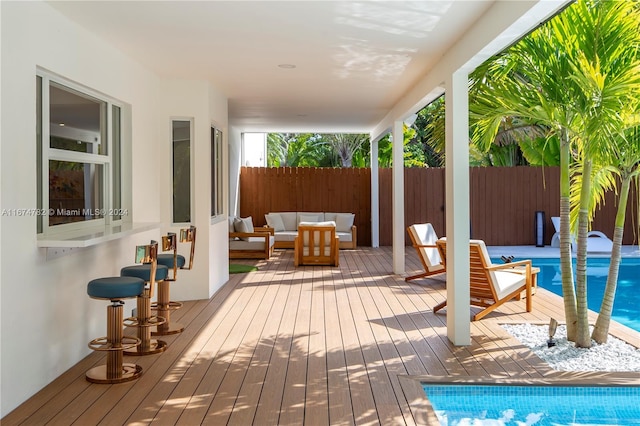 wooden deck with a fenced in pool and an outdoor living space