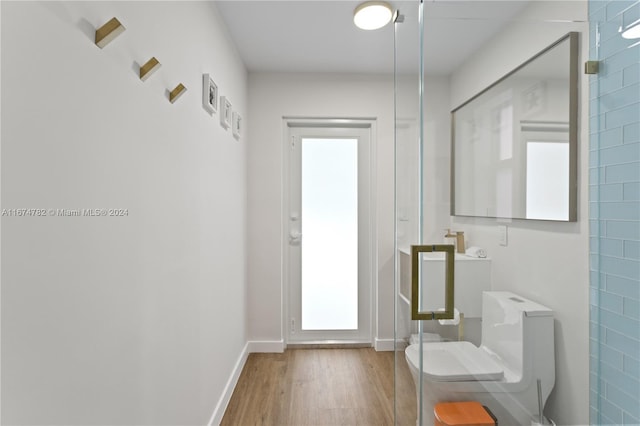 doorway with tile walls and hardwood / wood-style flooring