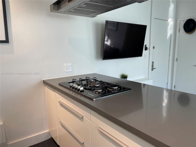 kitchen with black gas stovetop, white cabinets, and ventilation hood