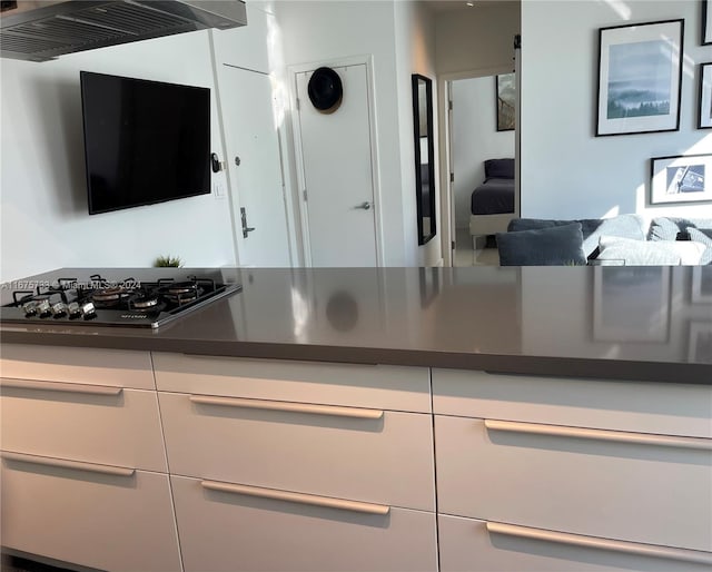 kitchen featuring white cabinetry, exhaust hood, and black gas cooktop