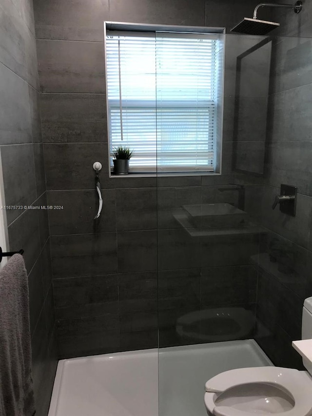 bathroom with tiled shower and toilet